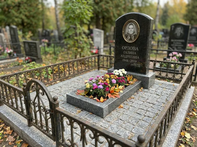 Благоустроенное захоронение с гранитной плиткой, оградой и цветником в Челябинске