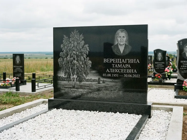 Памятник с гравировкой берёзы: широкая горизонтальная стела — берёза у поля, простор до горизонта, белая мраморная крошка с бордюром, работа «Верещагина» в Челябинске