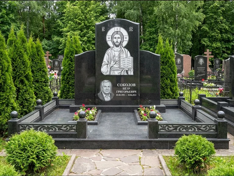 Памятник с гравировкой иконы: широкая горизонтальная лежачая плита-стела — икона в резной рамке-киоте, серая гравийная отсыпка с бордюром, работа «Богданова» в Челябинске