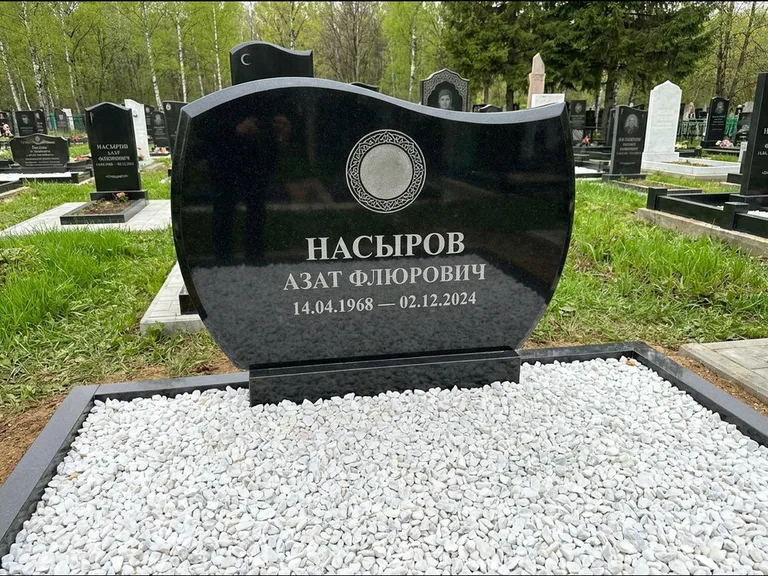 Мусульманский памятник: стела с волнообразным скошенным верхом — гравировка мечети под полумесяцем и звёздами, белая мраморная крошка с бордюром, работа «Насыров» в Челябинске