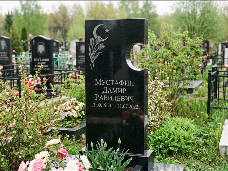 Мусульманский памятник: стела с боковым вырезом в форме полумесяца — гравировка минарета с полумесяцем, низкие кусты в цвету, работа «Мустафин» в Челябинске