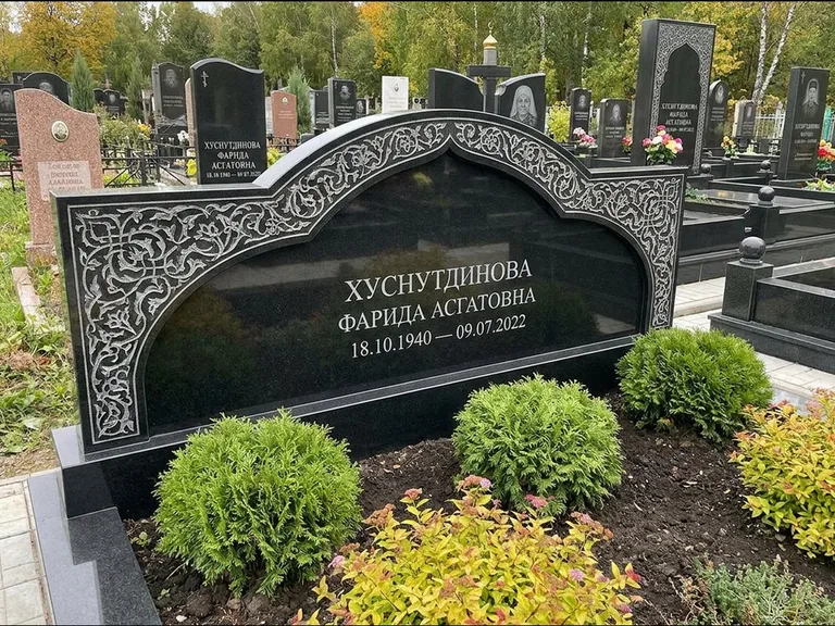 Мусульманский памятник: вытянутая горизонтальная семейная стела с аркой — белая гравировка силуэта мечети с минаретами, участок с декоративными кустами, работа «Зарипова» в Челябинске