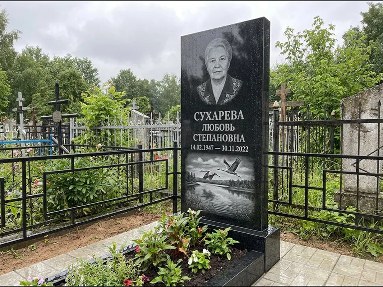Памятник с гравировкой журавлей — гравировка пары журавлей над гладью озера в нижней части, работа «Сухарева» в Челябинске
