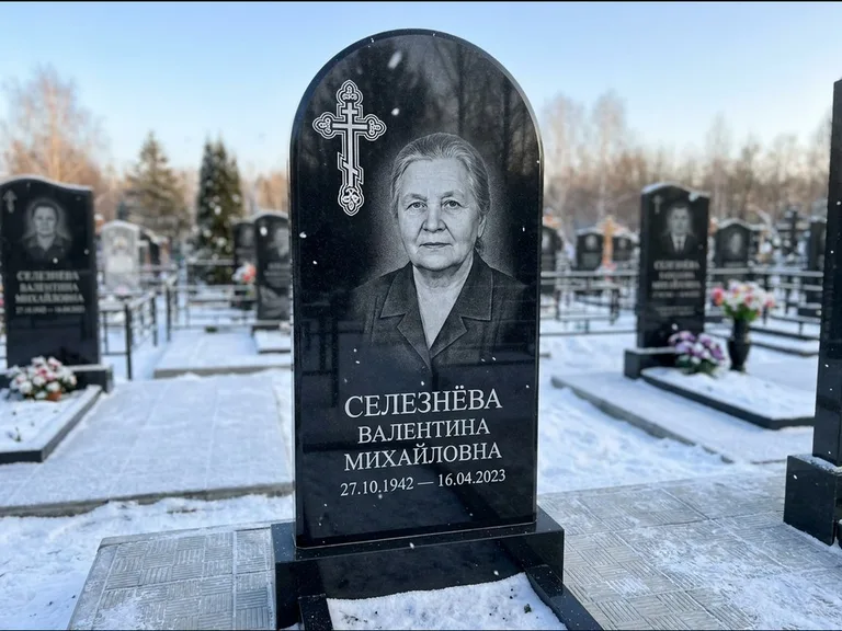 Памятник из чёрного гранита — массивная стела с крестом в лучах с крестом в лучах, работа «Одинцова» в Челябинске