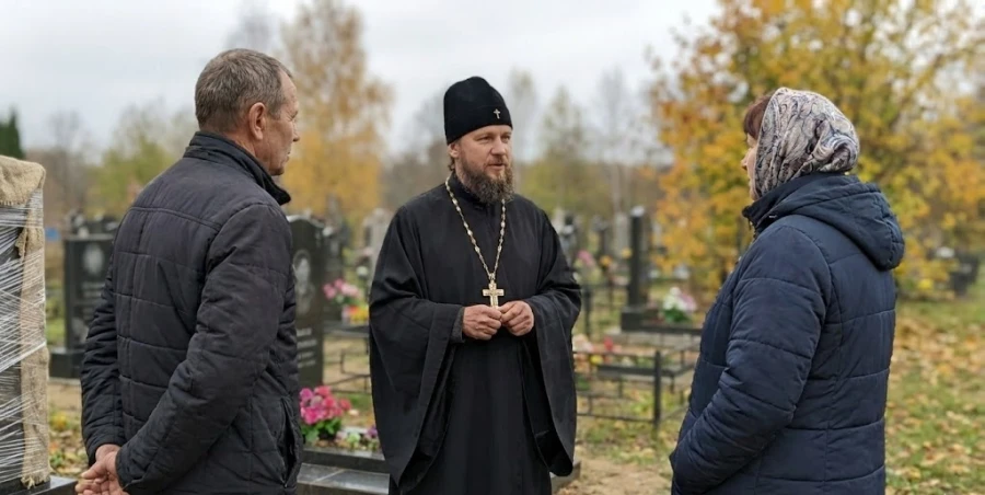 svyashchennik-beseduet-s-rodstvennikami-na-kladbishche